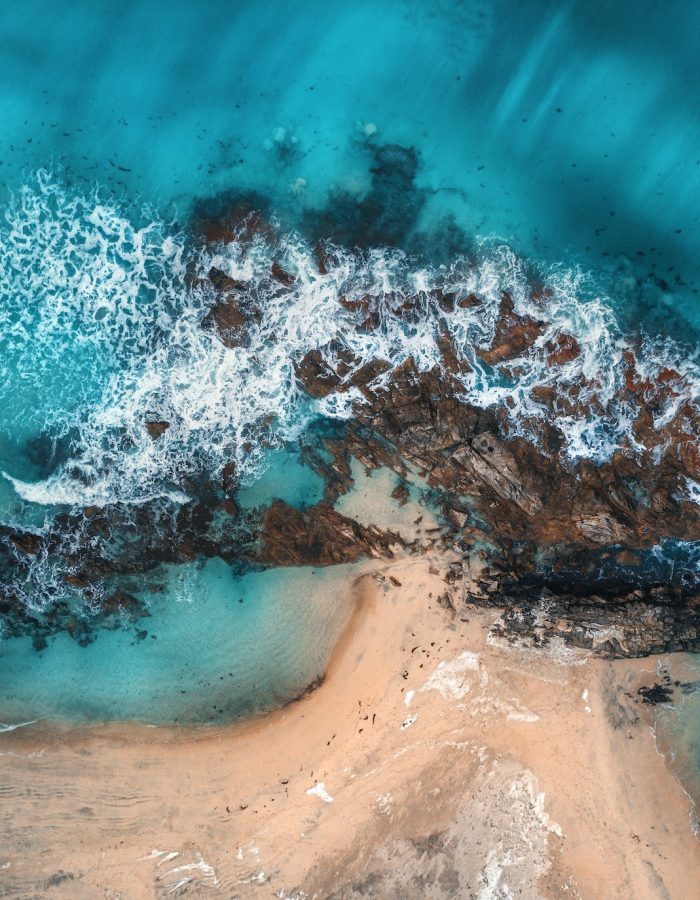 Aerial view of waves, rocks and transparent sea