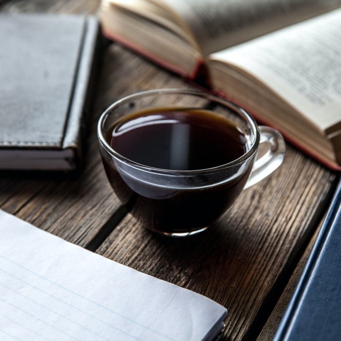 books and a cup of coffee on a wooden background